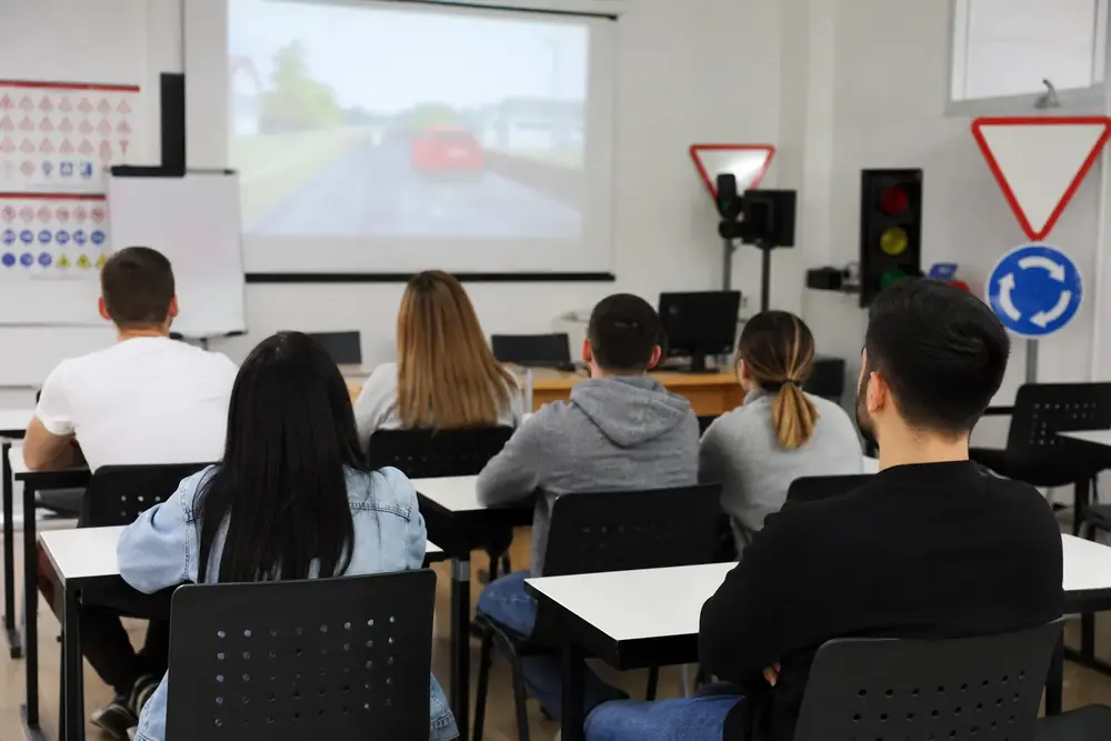 Aula de autoescuela con alumnos siguiendo una clase teórica