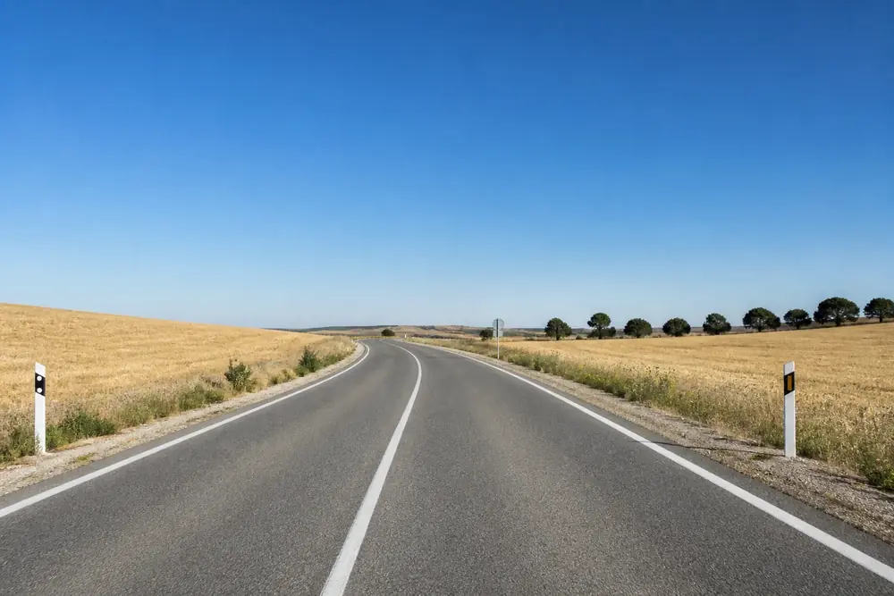 Carretera convencional de un carril por sentido entre campos
